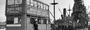 Merchant seamen receiving instruction in the art of anti-aircraft gunnery through the services of a mobile DEMS (Defensively Equipped Merchant Ships) course, from a converted bus.