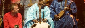 Damon Abarn on stage with Malian musicians Toumani Diabaté and Bassekou Kouyate, by Andy Buurman