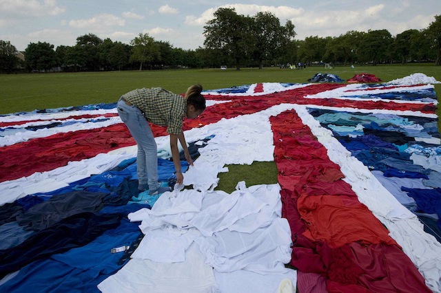 Marks & Spencers creates World's largest Union Jack flag from unwanted clothes as part of its Shwopping initiative. 2,100 unwanted clothes were uses to create giant clothes mosaic in East London today. Using 2,100 unwanted clothes items of clothes donated to the Shwopping initiative, Marks & Spencers, local volunteers and charity partner Oxfam joined forces to make the worls's ;largest Union Jack. Flag was created in a race against the clock to finish bbefore the winner of the 10km Open water Swi n at the Serpentine crosses the finish line - London, Brita