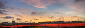 The modern London Bridge glows red, with Southwark Cathedral in the background. Image by mattomatto in the Londonist Flickr pool.