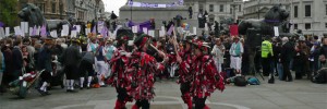 Morris Men doing their thing, with protesters doing their thing in the background. Photo by Dave.