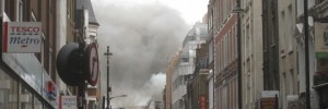 Smoke billows from the upper storey of buildings on Dean Street.